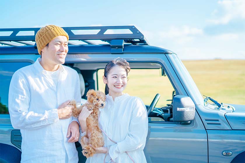 ドライブ中、愛犬と車を降りて休憩するカップル