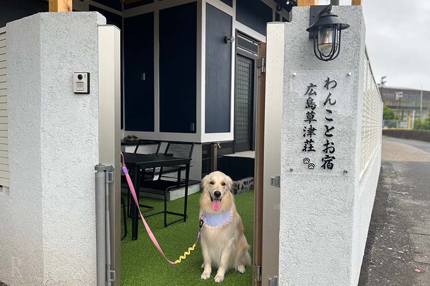 「わんことお宿 広島草津荘」の看板と一緒に写真撮影